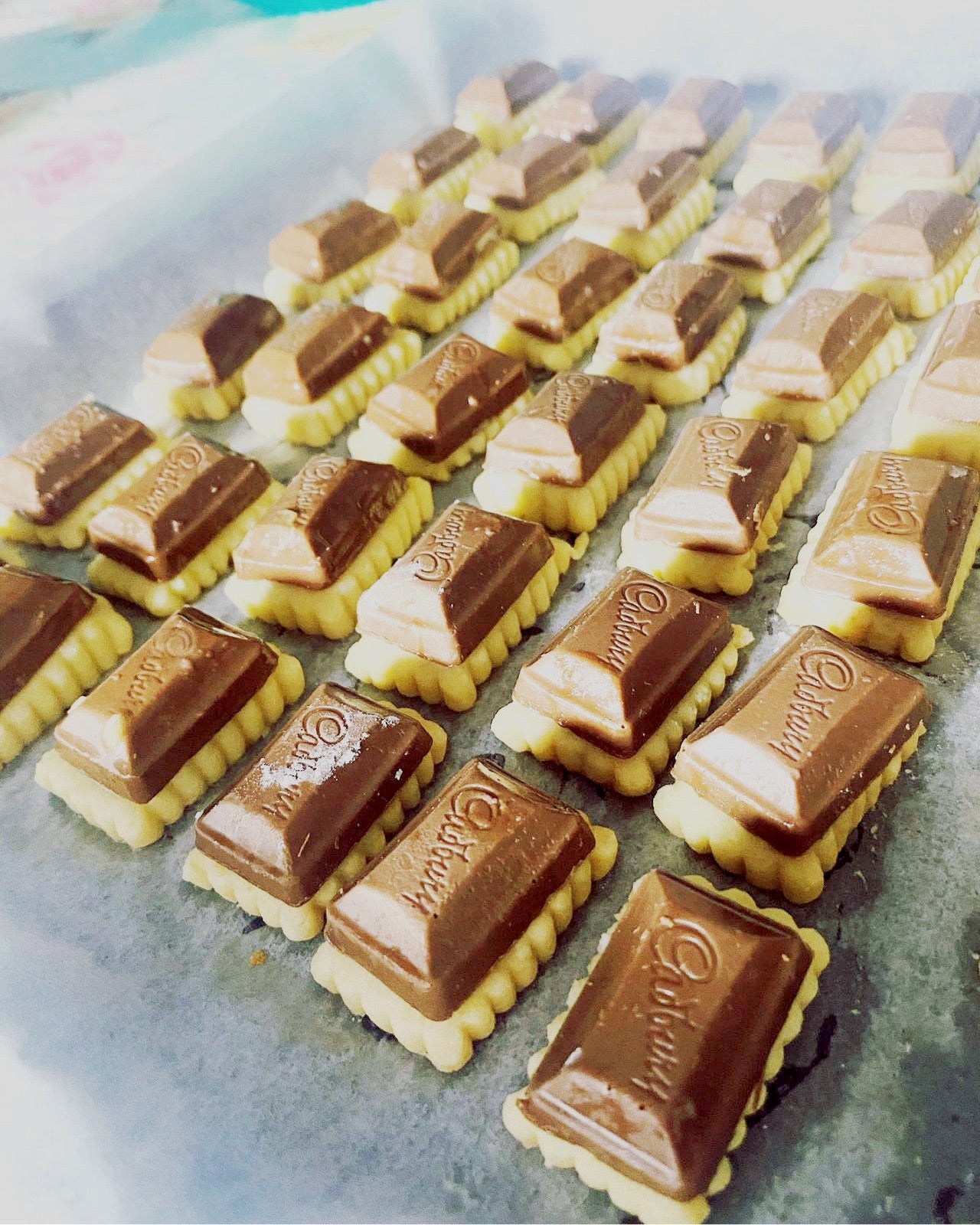 It's the highly reviewed cadbury milk cheese tarts. Grated mozarella cheese on a buttery base with cadbury chocolate atop for that crunchy effect! CRUNCH! Great for kids and adults! A personal favourite. ✨Freshly packed in 30's and 50's✨